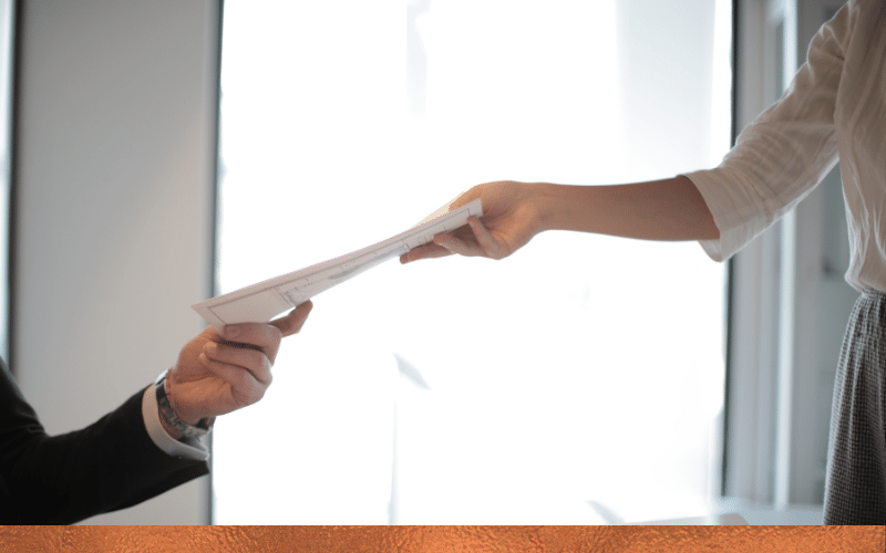 Two people exchanging documents, symbolizing the home equity loan and HELOC application process