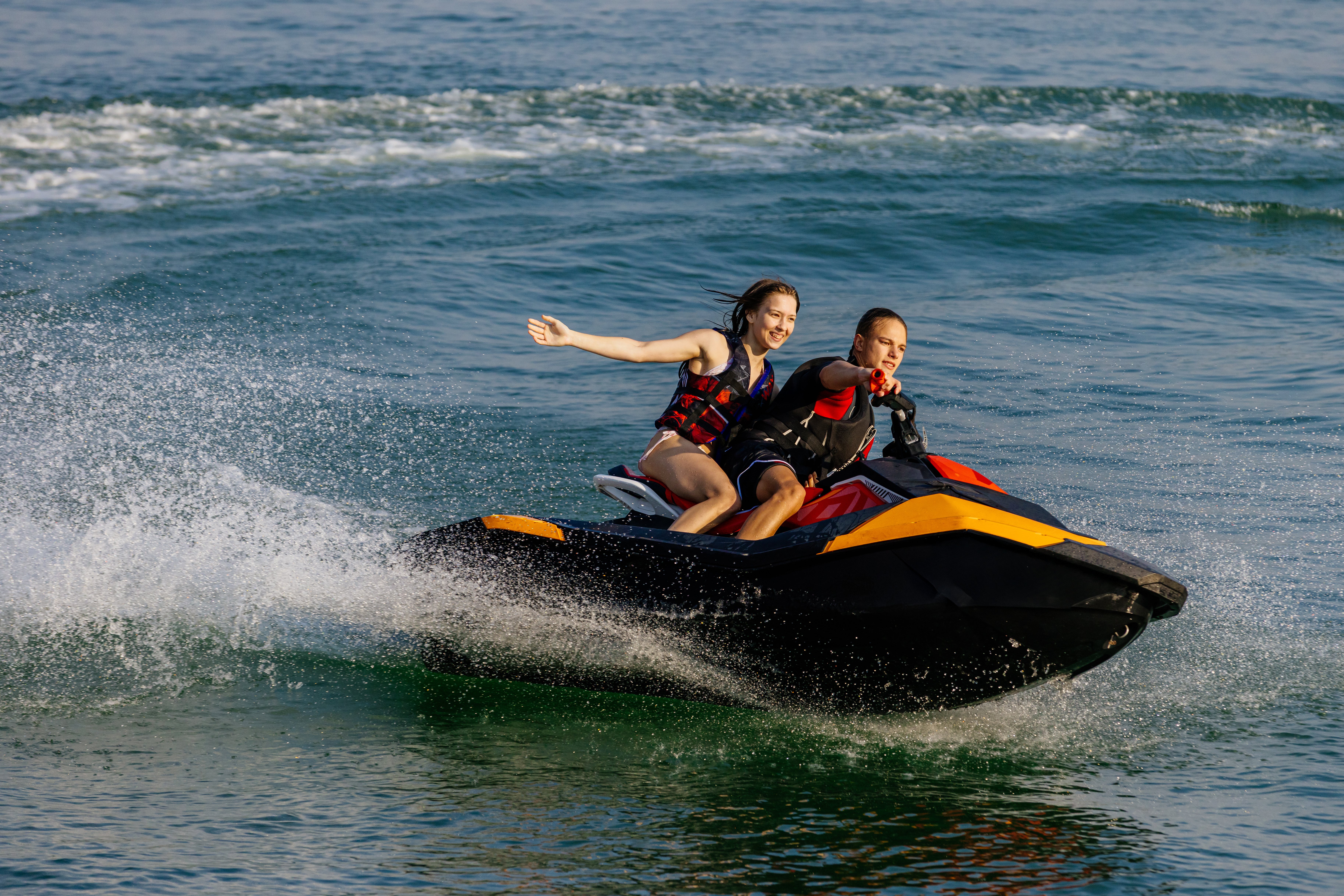 Happy couple riding a jet ski.