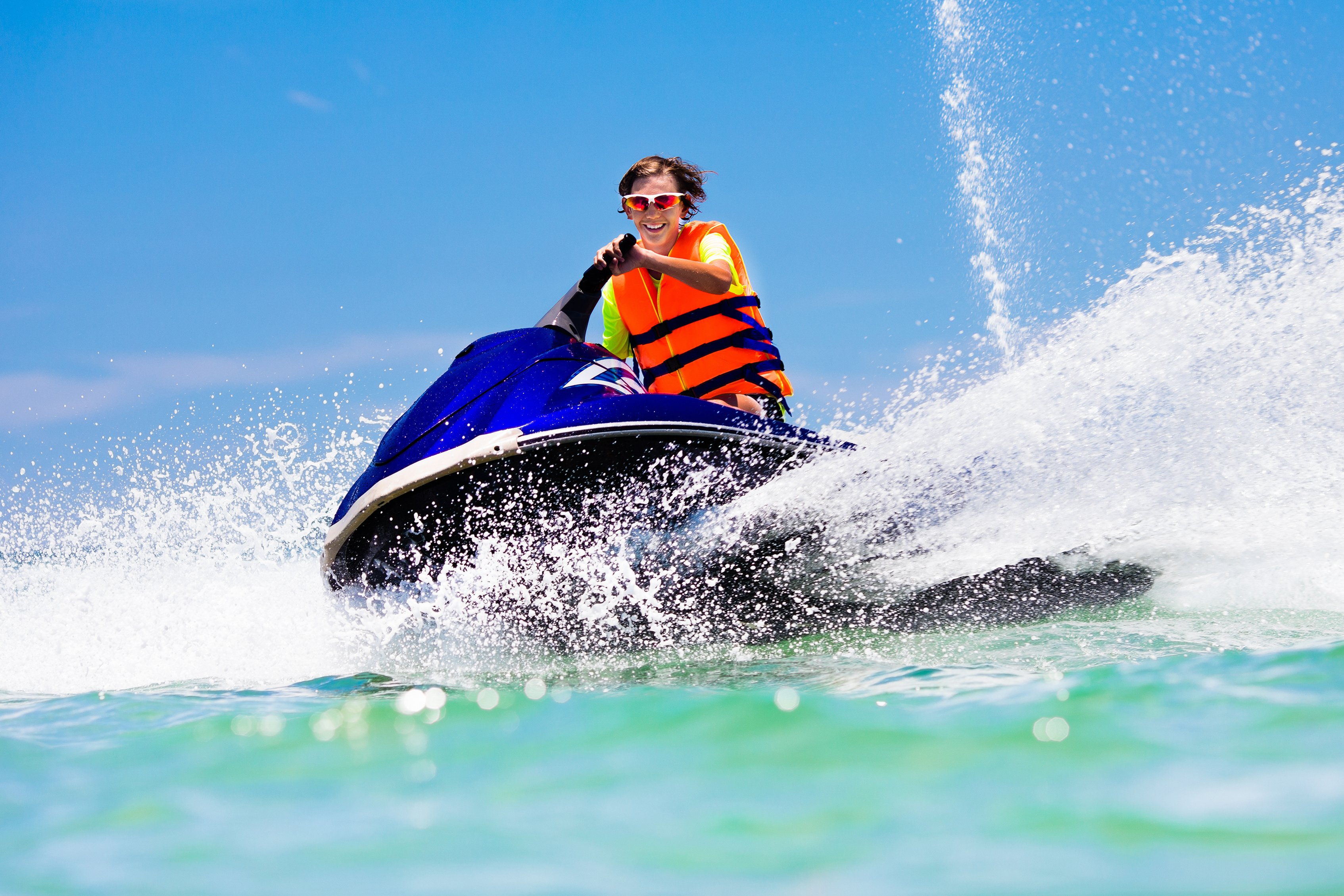 Teen boy riding a jet ski.