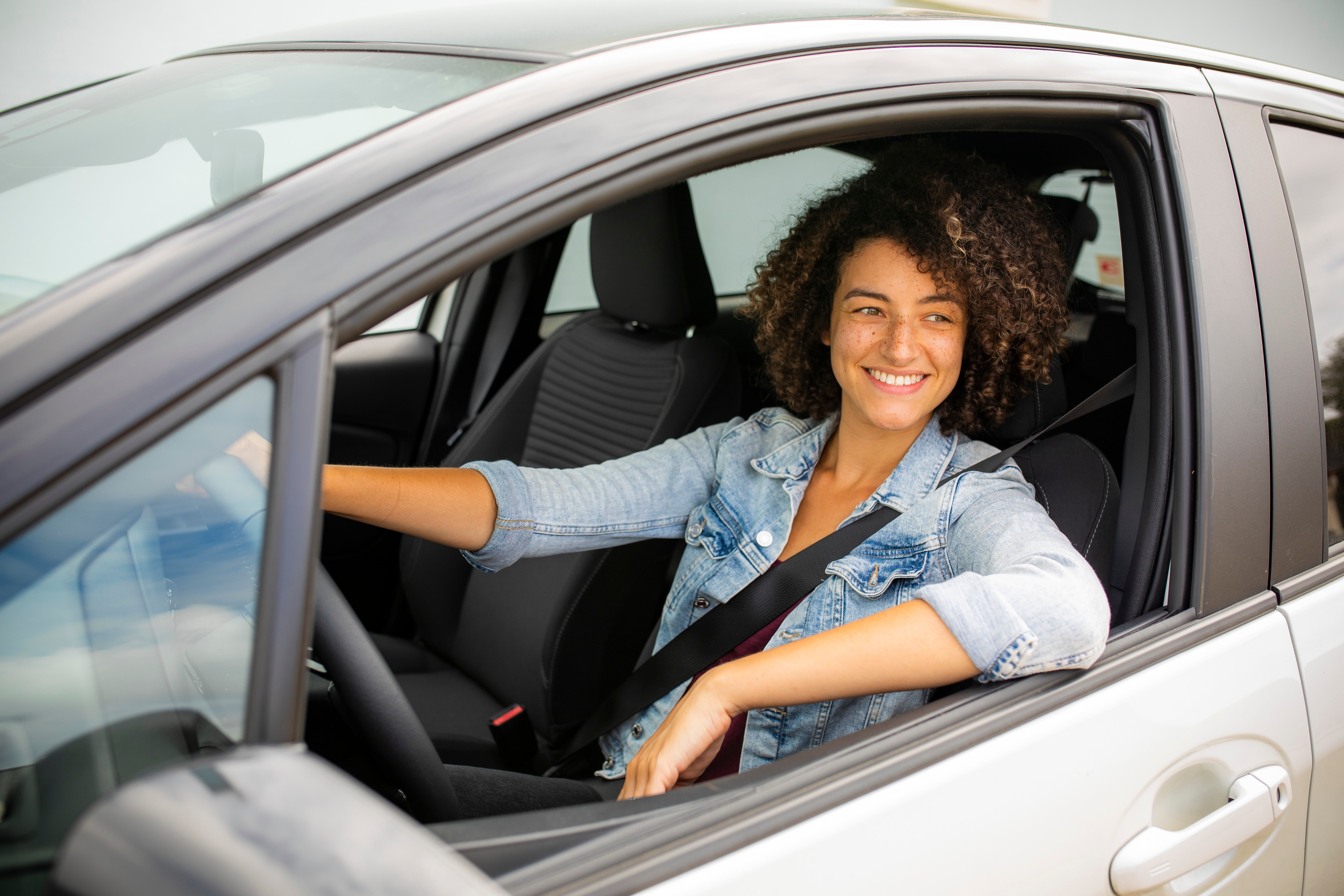 Woman sitting in the driver's seat of a car.