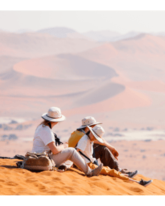 family-sitting-on-california-sand-dunes