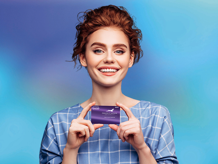 Woman holding a GCU Debit Card from a free checking account.