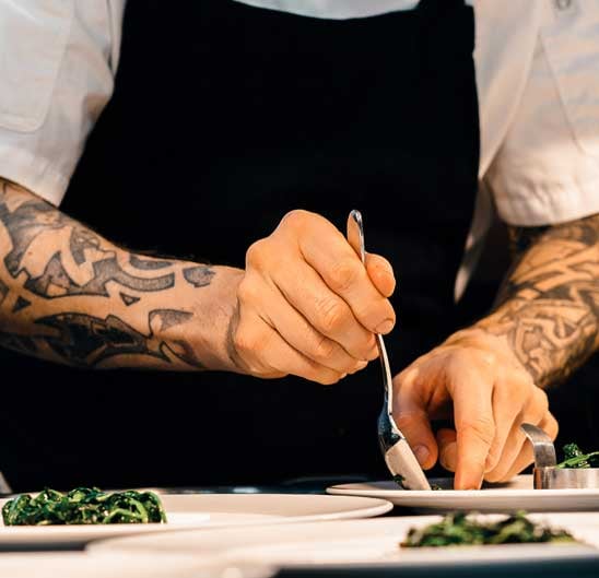 Chef preparing food after getting a Commercial Real Estate loan for his business.