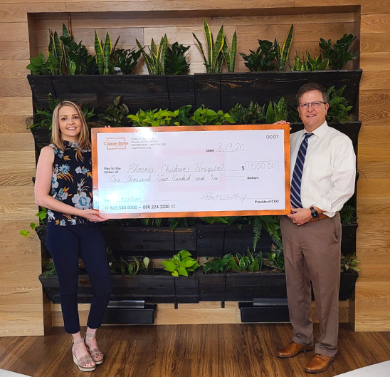 Copper State CEO and Branch Manager holding a check