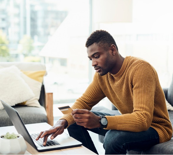 Male Sitting On The Couch Using Credit Card