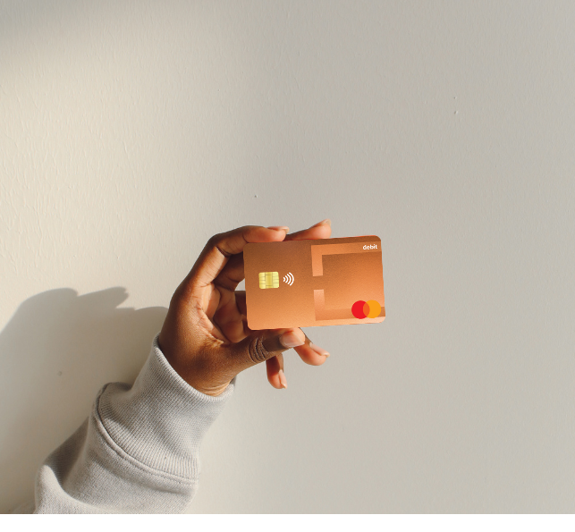 Hand holding a Copper State CU debit card 
