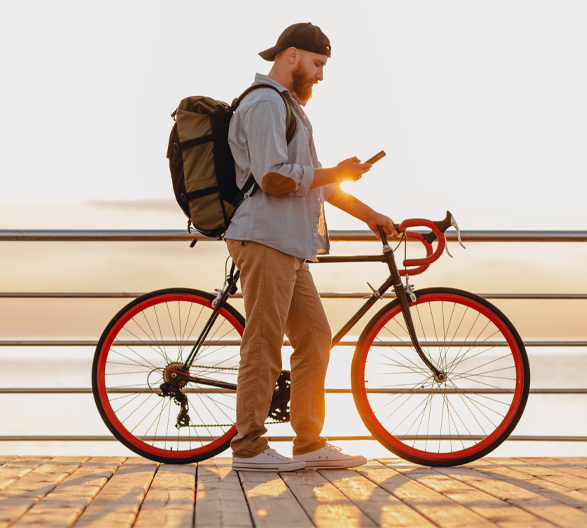 man on cell phone holding bike