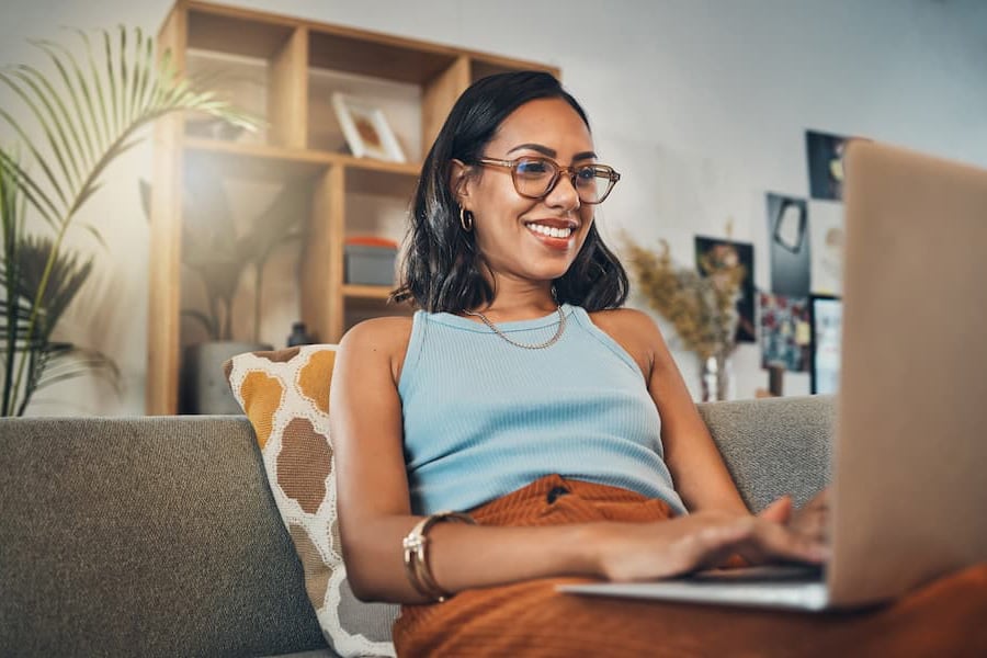 Woman smiling as she applies for a personal loan online.