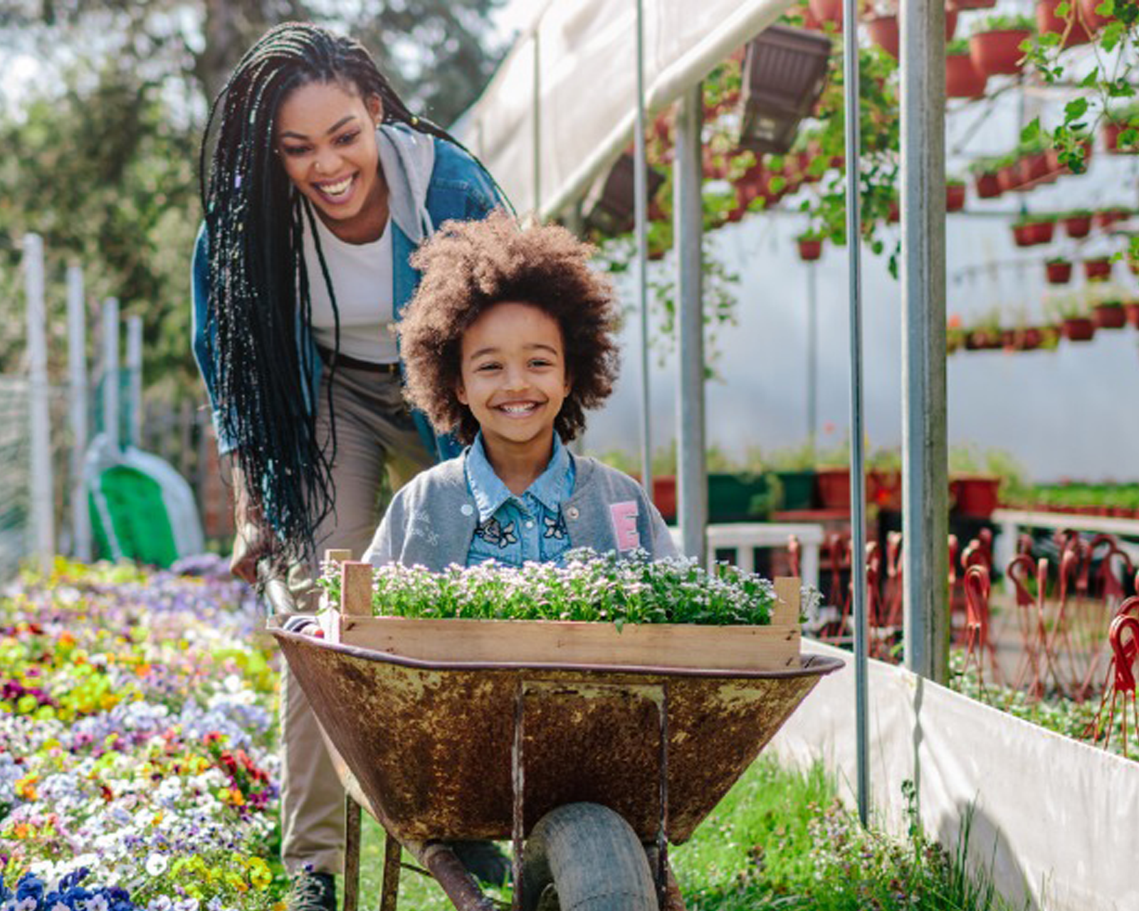 mom pushing daughter in wheelbarrow