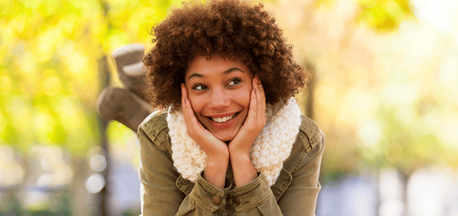 A smiling woman thinks about how she can get a home loan.