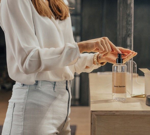 business-woman-cleaning-hands-with-sanitizer-in-the-office