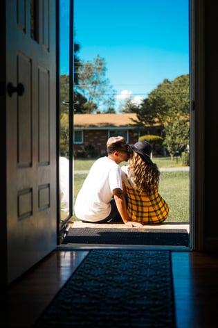 couple sitting in doorway of their brand new house