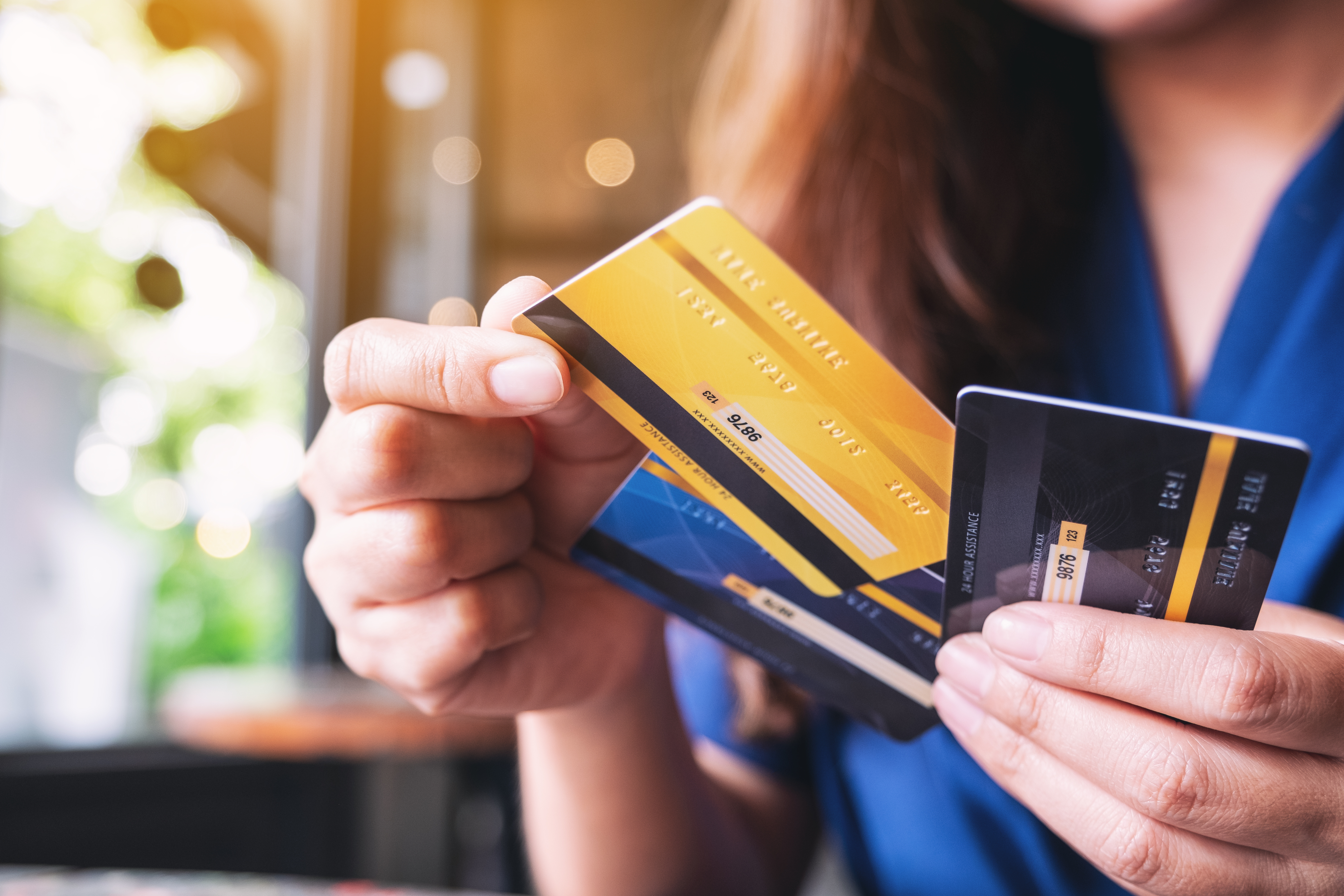 A woman chooses which credit card to use after debt consolidation.