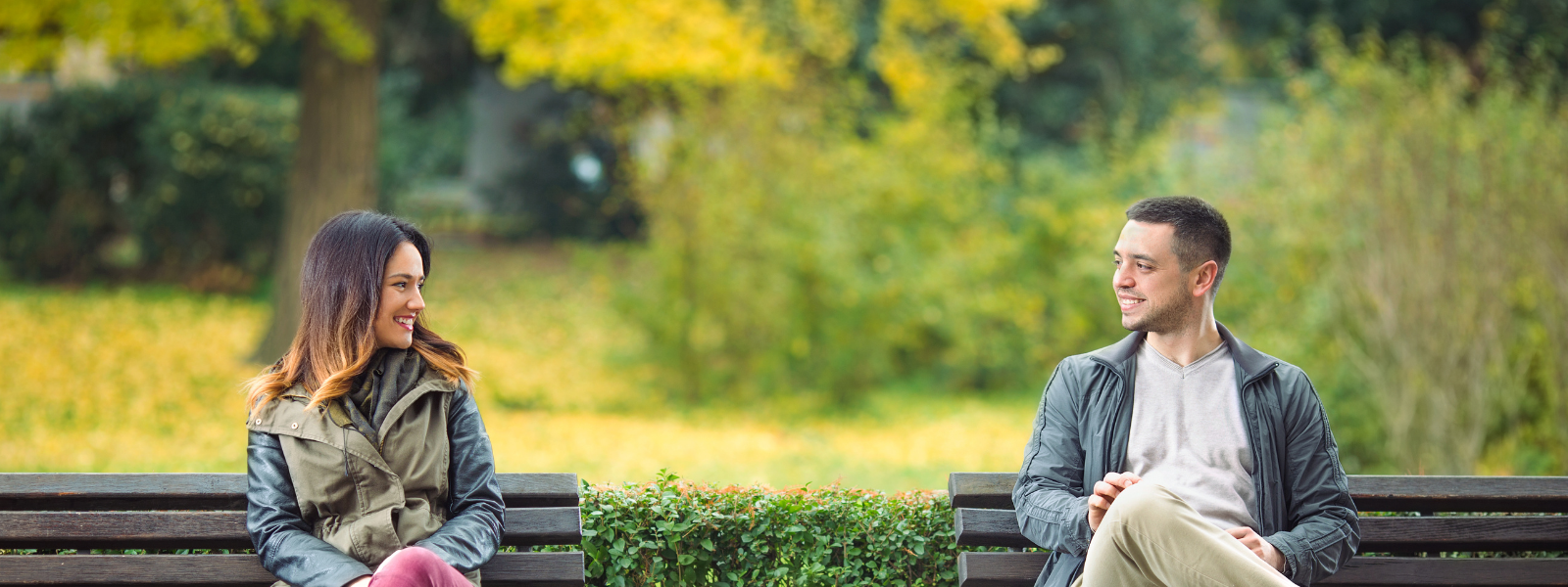 couple-sitting-opposite-on-benches