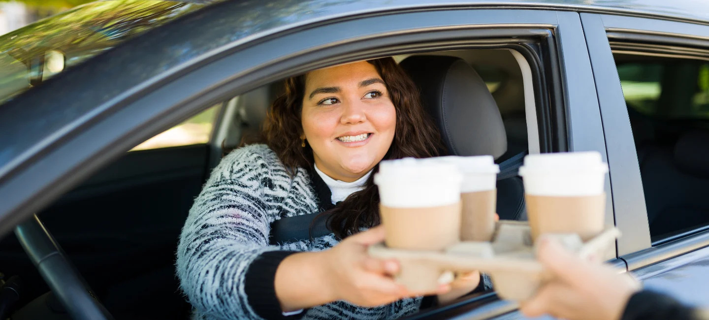 woman-picking-up-coffee-from-drive-thru woman-picking-up-coffee-from-drive-thru